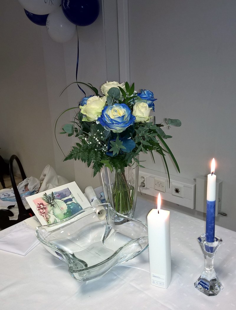 Kastepöytä, jossa kastemalja, kynttilät, kukat ja kummitodistukset ja myös raamattu asetetaan